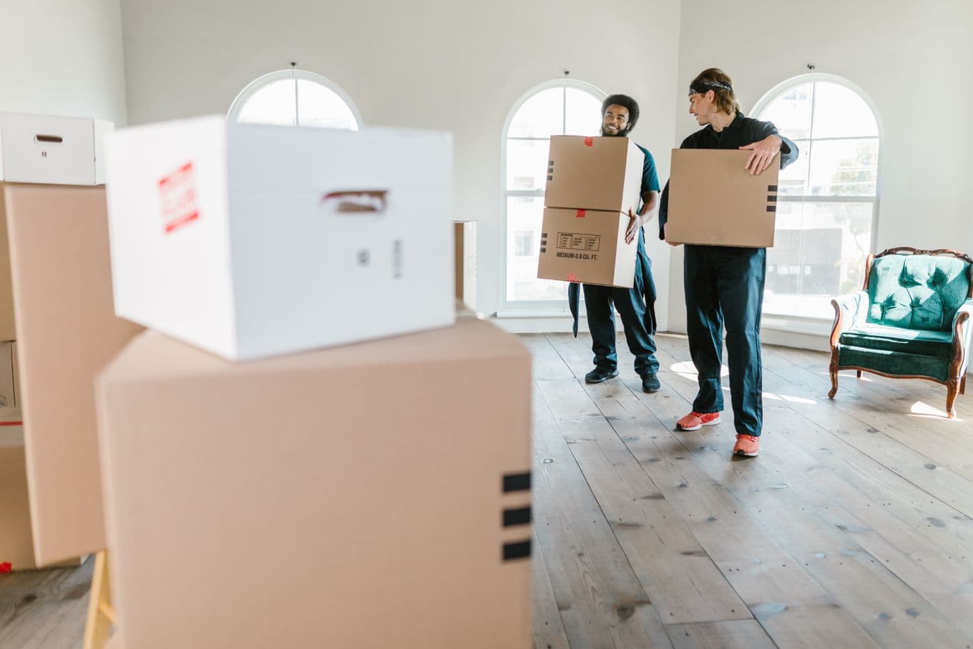 Two people carrying boxes during a relocation